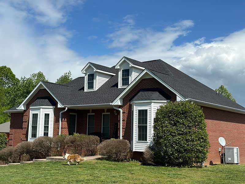 Front view of a mid-class residential home with brands new charcoal GAF shingles installed by POWCO