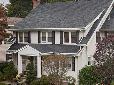 Front view of a typical, mid-class home with gray GAF shingles on its roof
