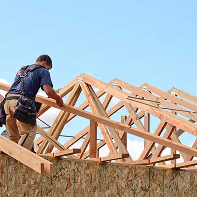 Worker building the wooden frame of a new roof