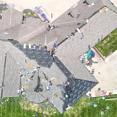 Crew replacing shingles on a large roof